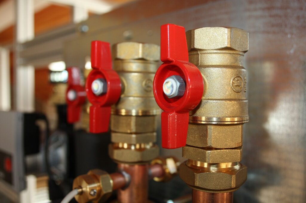 Brass plumbing valves with red handles, showcasing efficient plumbing solutions for repairs in Saint Clair Shores.