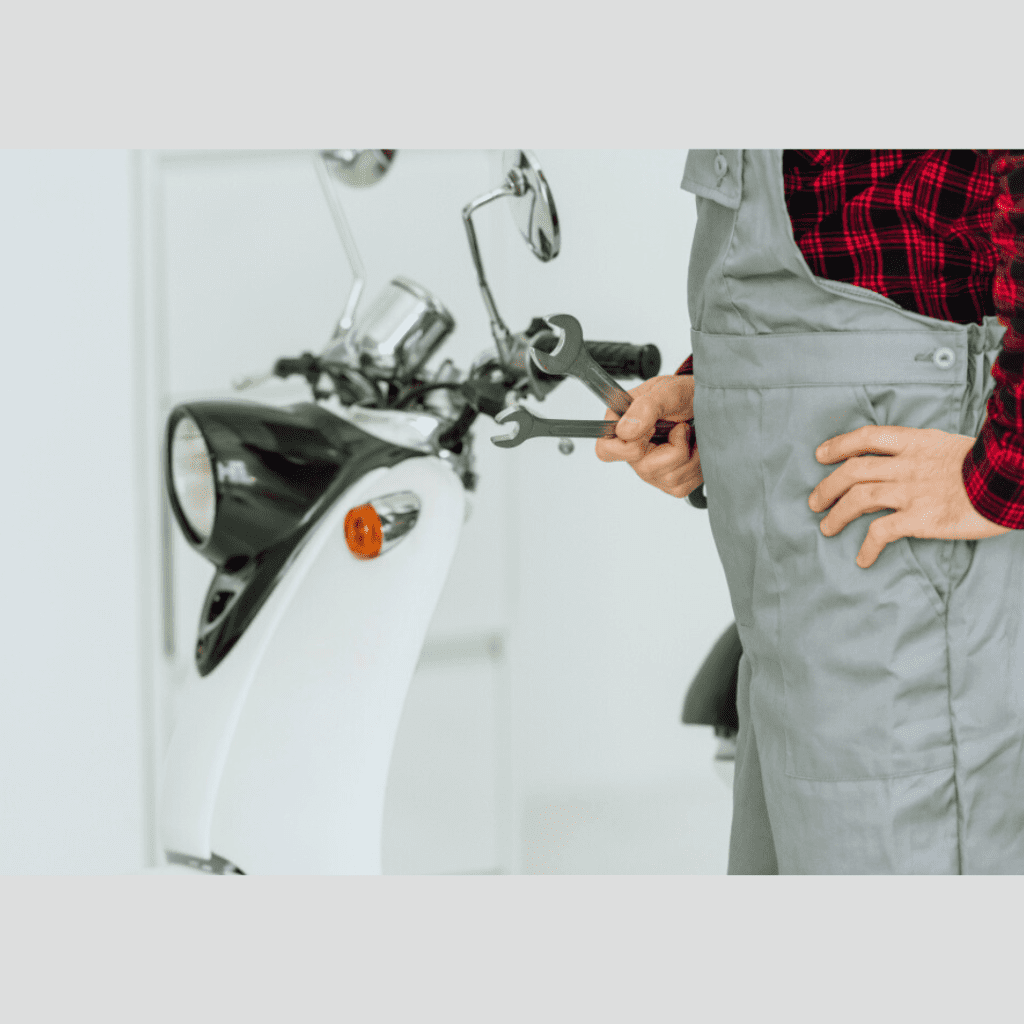 Mechanic holding a wrench next to a motorcycle, showcasing expertise in plumbing and repair services relevant to Frost & Kretsch Plumbing Inc in Sterling Heights.