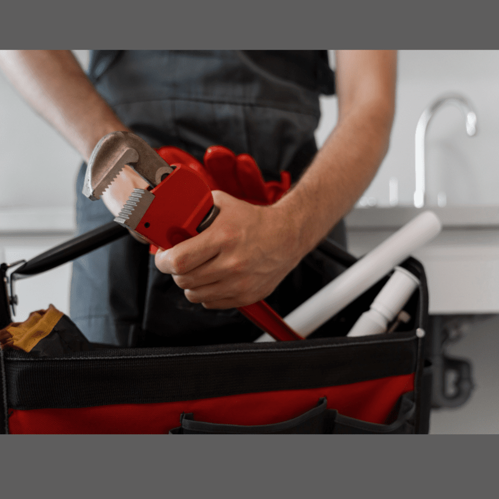 Plumber holding adjustable wrench and pipe tools in a service bag, representing Frost & Kretsch Plumbing Inc. services in Sterling Heights.