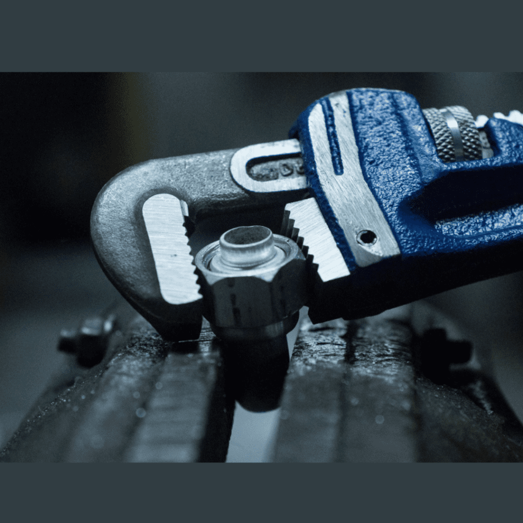 Adjustable wrench gripping a plumbing fitting, emphasizing tools used for plumbing repairs in Eastpointe by Frost & Kretsch Plumbing Inc.